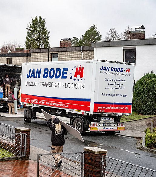 haushaltsaufloesungen-entruempelungen-spedition-jan-bode Umzugshelferin schleppt auf ihrer Schulter eine Schranktür zu einem LKW