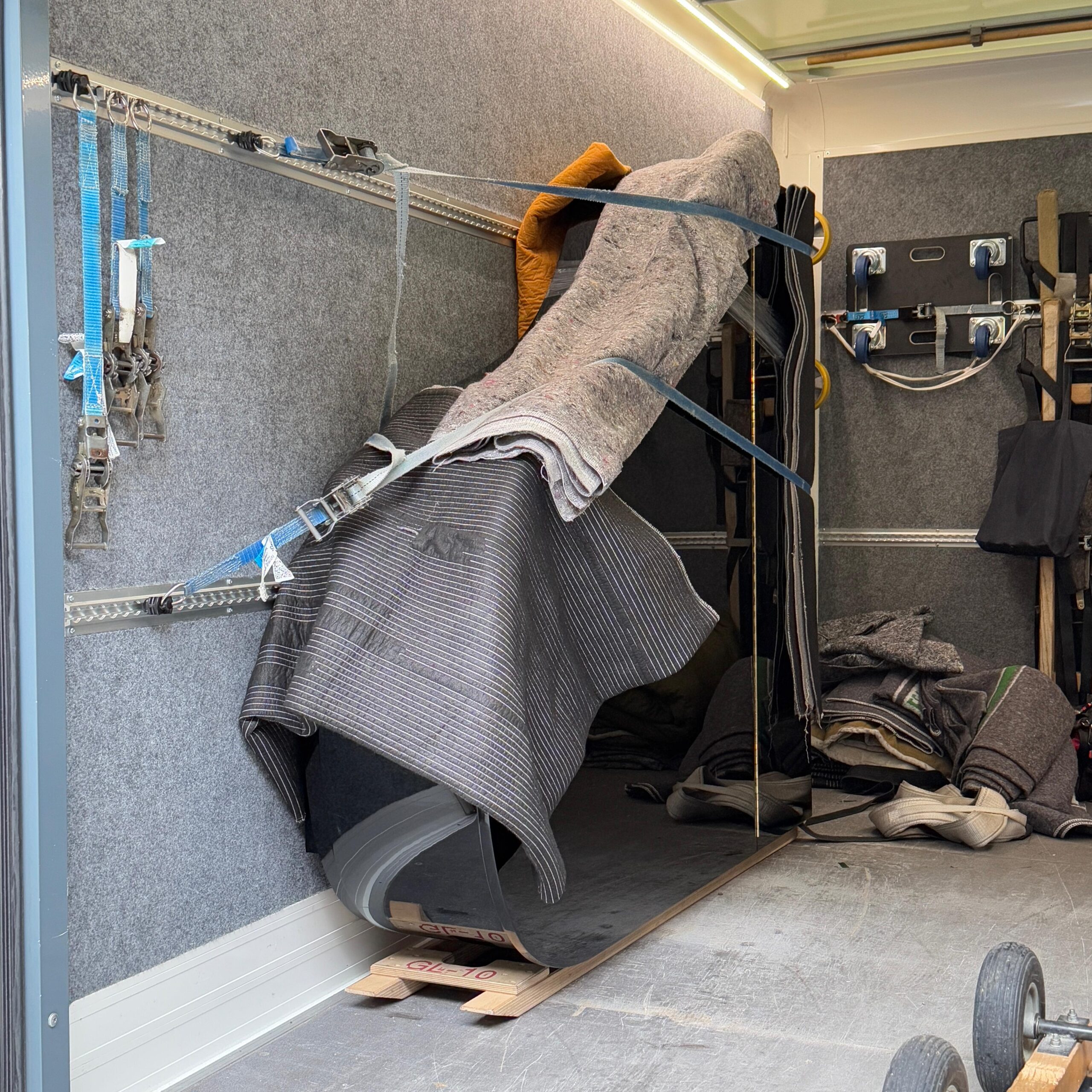 fluegel-gesichert-transportschutz-lkw-janbode Ein Flügel ist mit Decken & Gurten geschützt in einem Transportfahrzeug gesichert